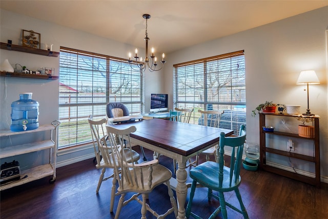 dining area featuring a wealth of natural light, dark hardwood / wood-style floors, and an inviting chandelier