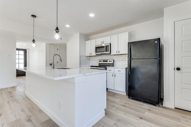 kitchen featuring a center island with sink, sink, white cabinetry, and stainless steel appliances