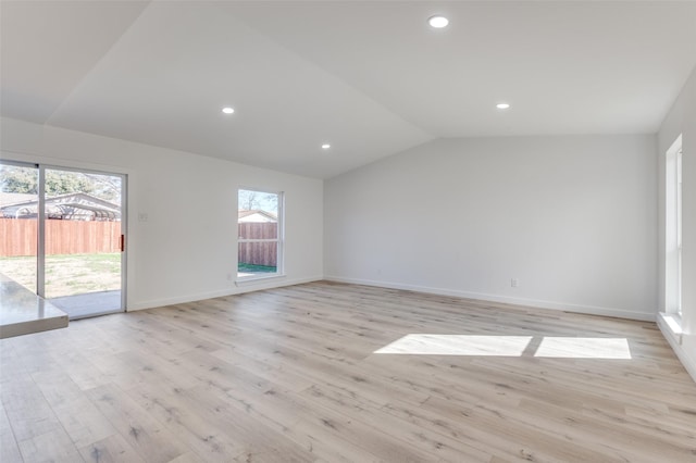 empty room featuring light wood-type flooring and lofted ceiling