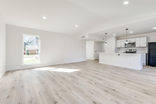 unfurnished living room featuring light hardwood / wood-style floors and lofted ceiling