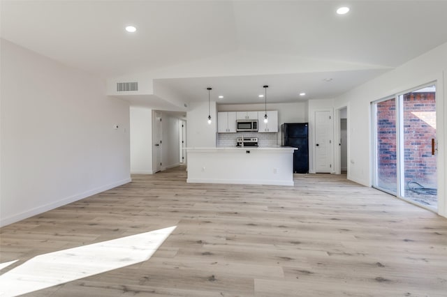 kitchen with a center island with sink, white cabinets, lofted ceiling, and hanging light fixtures