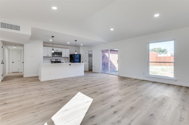 unfurnished living room featuring light wood-type flooring and lofted ceiling