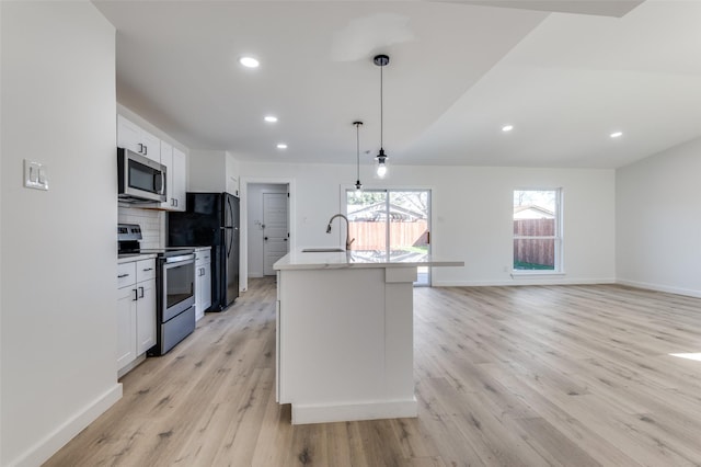 kitchen featuring stainless steel appliances, backsplash, pendant lighting, a kitchen island with sink, and white cabinets