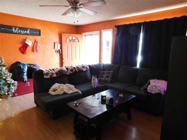 living room featuring a textured ceiling, ceiling fan, and hardwood / wood-style floors