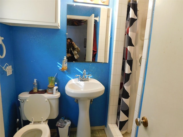 bathroom featuring sink, toilet, and a shower with curtain