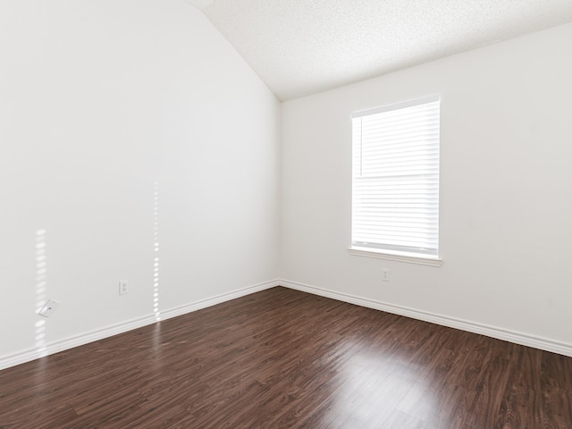 unfurnished room featuring a textured ceiling, vaulted ceiling, and dark wood-type flooring