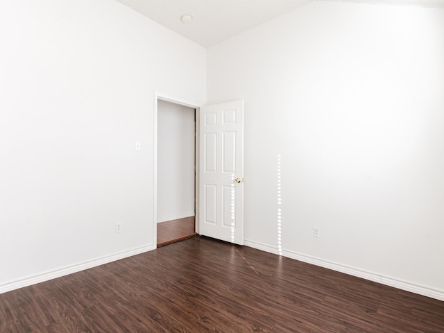 spare room with dark wood-type flooring and a high ceiling