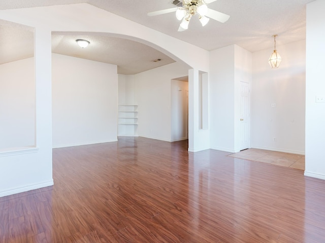 empty room with ceiling fan, vaulted ceiling, and hardwood / wood-style flooring