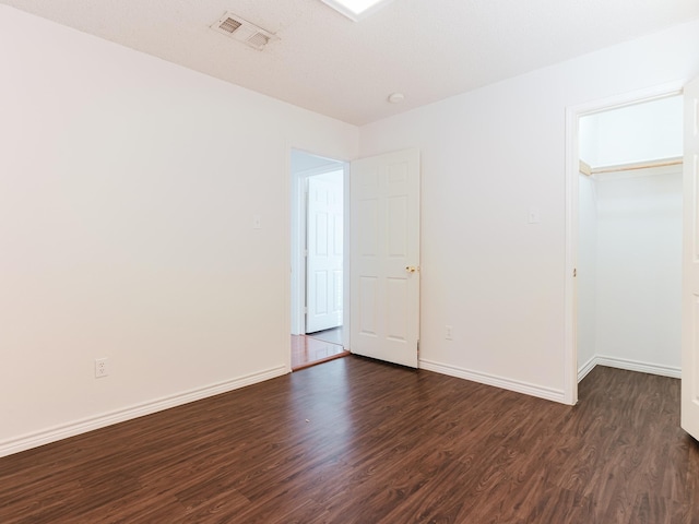 unfurnished bedroom featuring a closet and dark wood-type flooring