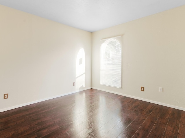 unfurnished room with dark hardwood / wood-style flooring