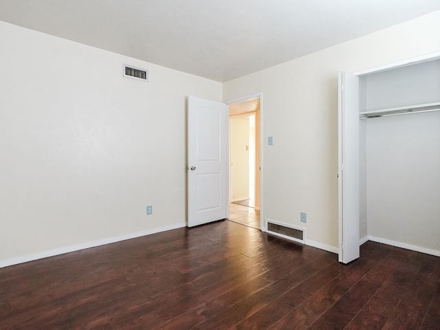 unfurnished bedroom featuring dark hardwood / wood-style floors and a closet