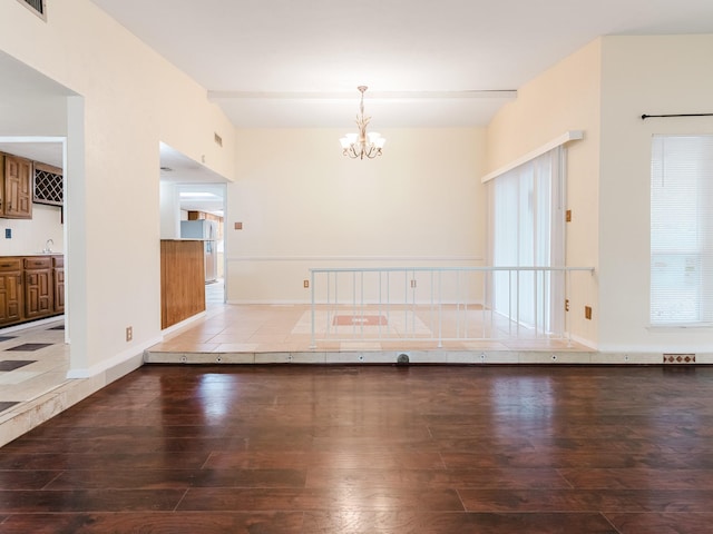 interior space with hardwood / wood-style floors, a notable chandelier, sink, and beamed ceiling