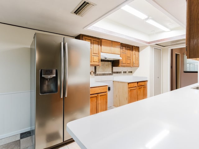 kitchen featuring stainless steel fridge with ice dispenser and decorative backsplash