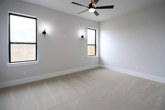 spare room featuring carpet flooring, ceiling fan, and a wealth of natural light