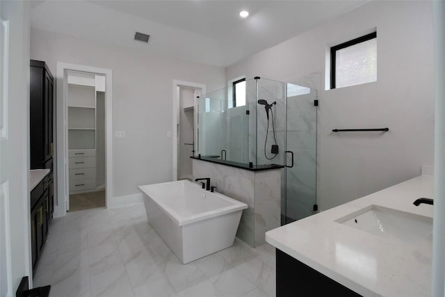 bathroom with vanity, a healthy amount of sunlight, and separate shower and tub