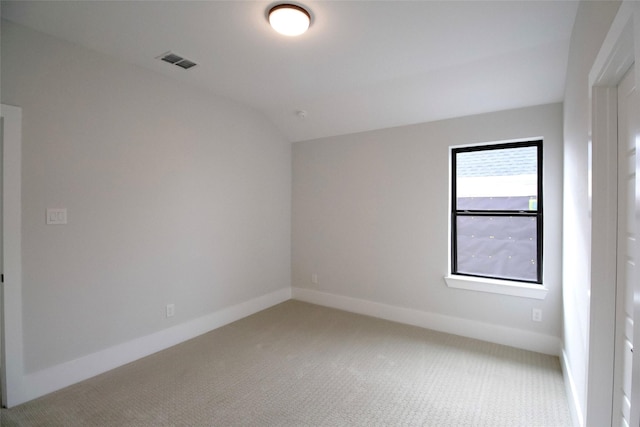 unfurnished room featuring lofted ceiling and carpet floors