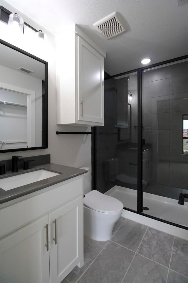 bathroom featuring walk in shower, vanity, and toilet