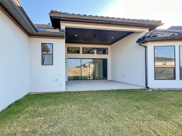 back of house featuring a patio area, ceiling fan, and a yard