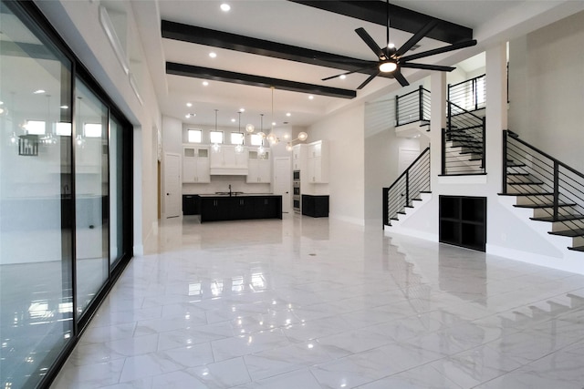 interior space with beamed ceiling, ceiling fan with notable chandelier, and sink