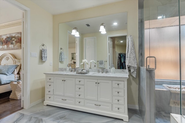 ensuite bathroom featuring marble finish floor, double vanity, visible vents, a shower stall, and baseboards