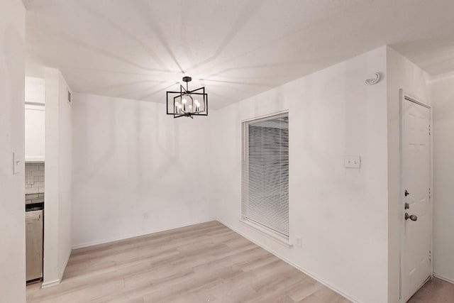 unfurnished dining area featuring light hardwood / wood-style flooring and a chandelier