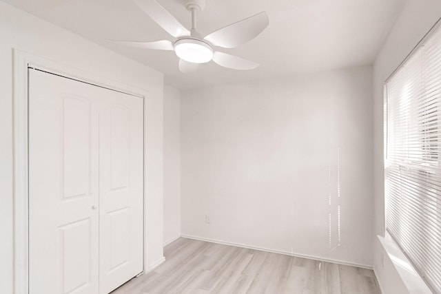 unfurnished bedroom with ceiling fan, a closet, and light hardwood / wood-style flooring