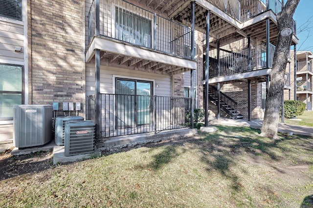 back of house featuring central AC unit and a balcony