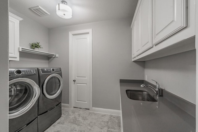 laundry room featuring cabinets, separate washer and dryer, and sink