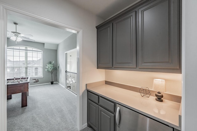 kitchen featuring light carpet, ceiling fan, and gray cabinets