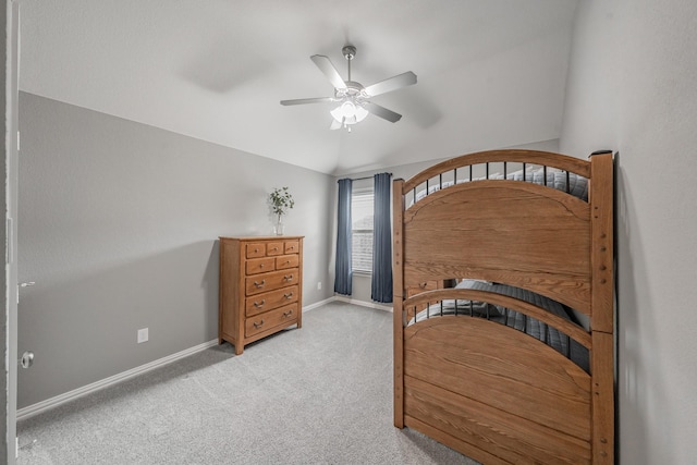 bedroom with ceiling fan, light colored carpet, and vaulted ceiling