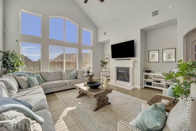 living room featuring ceiling fan and a towering ceiling