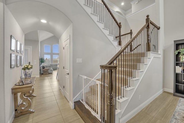 stairway featuring a towering ceiling