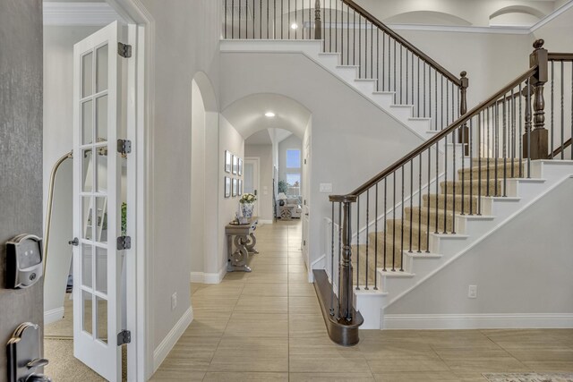 tiled entryway with french doors and a towering ceiling