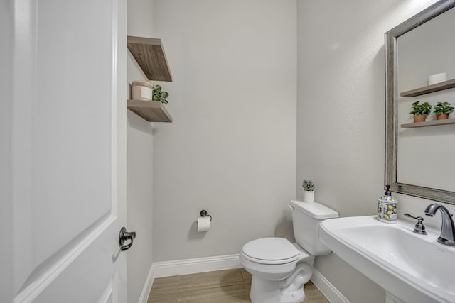 bathroom featuring sink, hardwood / wood-style floors, and toilet