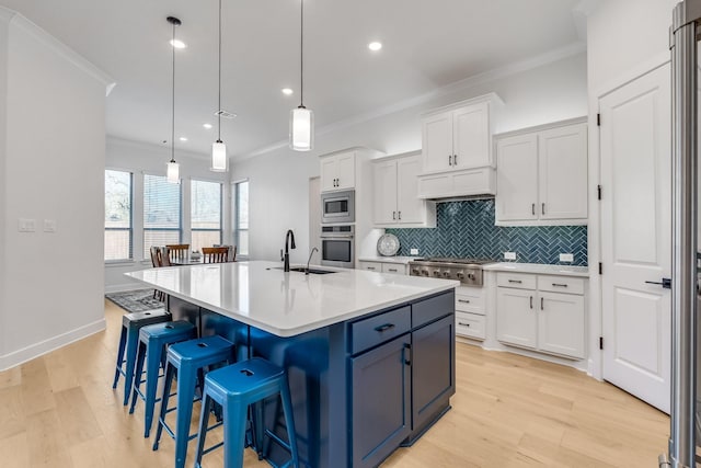 kitchen with pendant lighting, white cabinetry, crown molding, and stainless steel appliances