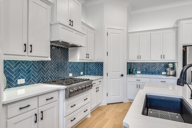 kitchen with decorative backsplash, sink, white cabinets, and stainless steel gas cooktop