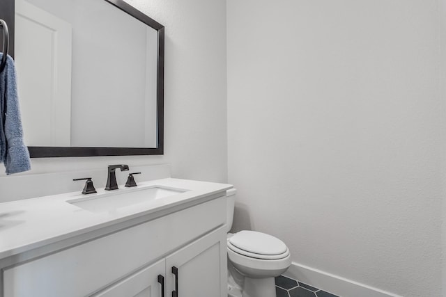 bathroom featuring tile patterned flooring, vanity, and toilet