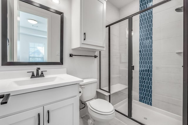 bathroom featuring vanity, a shower with shower door, and toilet