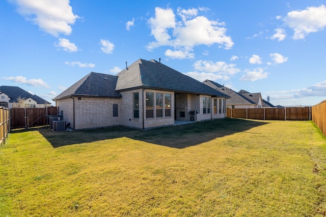 rear view of property with a yard and central AC