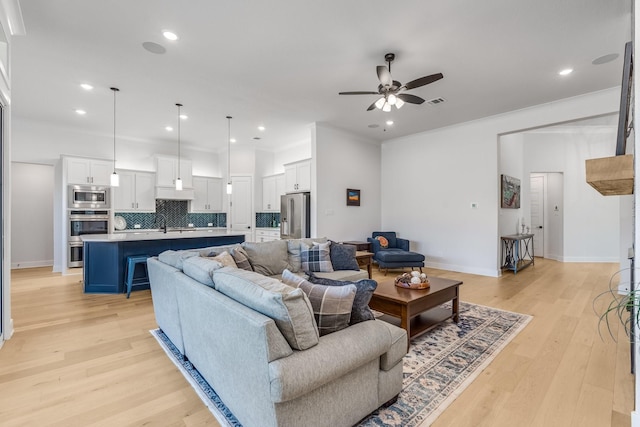 living room with ceiling fan and light wood-type flooring