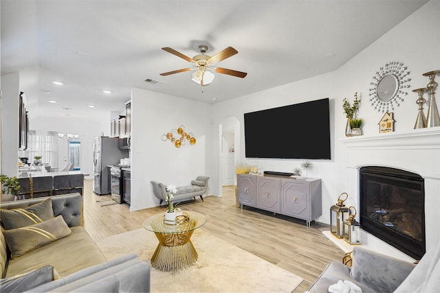 living room with ceiling fan and light wood-type flooring