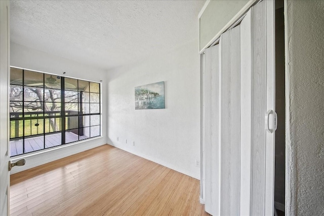 spare room featuring wood-type flooring and a textured ceiling