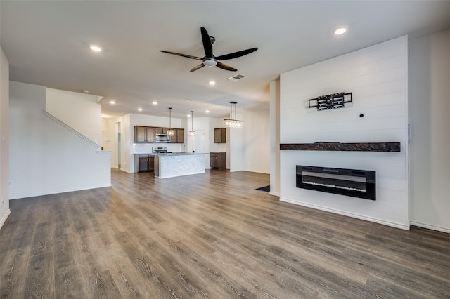 unfurnished living room with dark wood-type flooring and ceiling fan