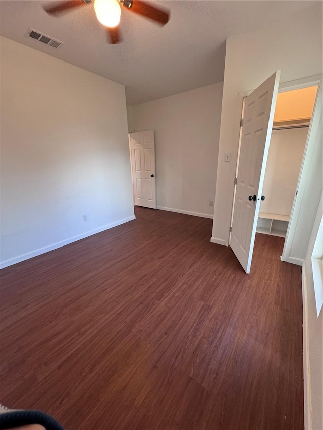 empty room with dark hardwood / wood-style floors and ceiling fan