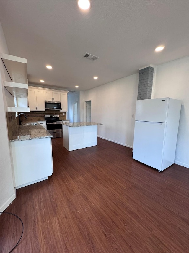 kitchen with backsplash, sink, dark hardwood / wood-style floors, white cabinetry, and stainless steel appliances