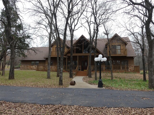 view of front of home with a balcony and a front yard