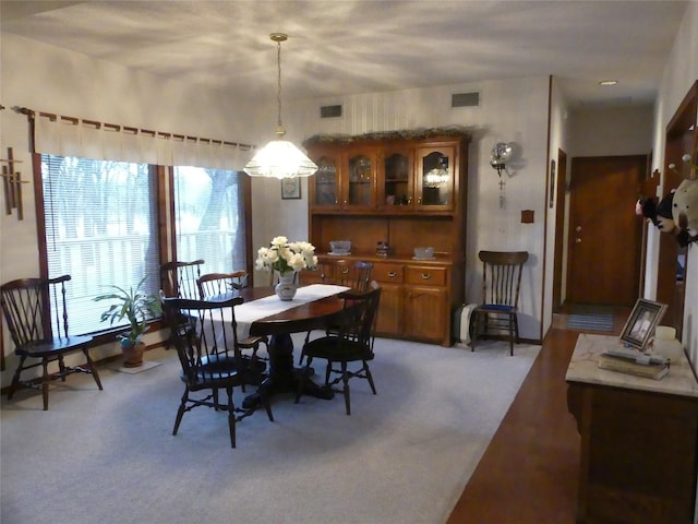 dining room featuring visible vents and light carpet