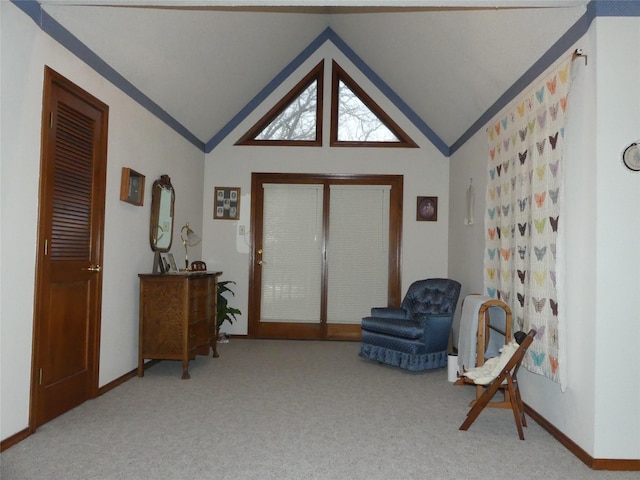 sitting room with light colored carpet, vaulted ceiling, and baseboards