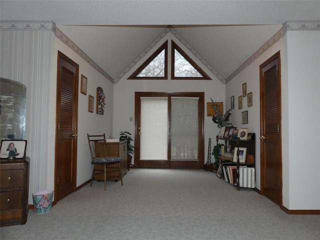 sitting room with carpet floors and vaulted ceiling