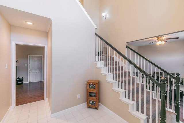 stairway featuring ceiling fan and tile patterned flooring